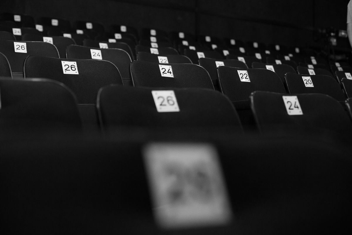 Numbered theater seats waiting for an audience, in black and white