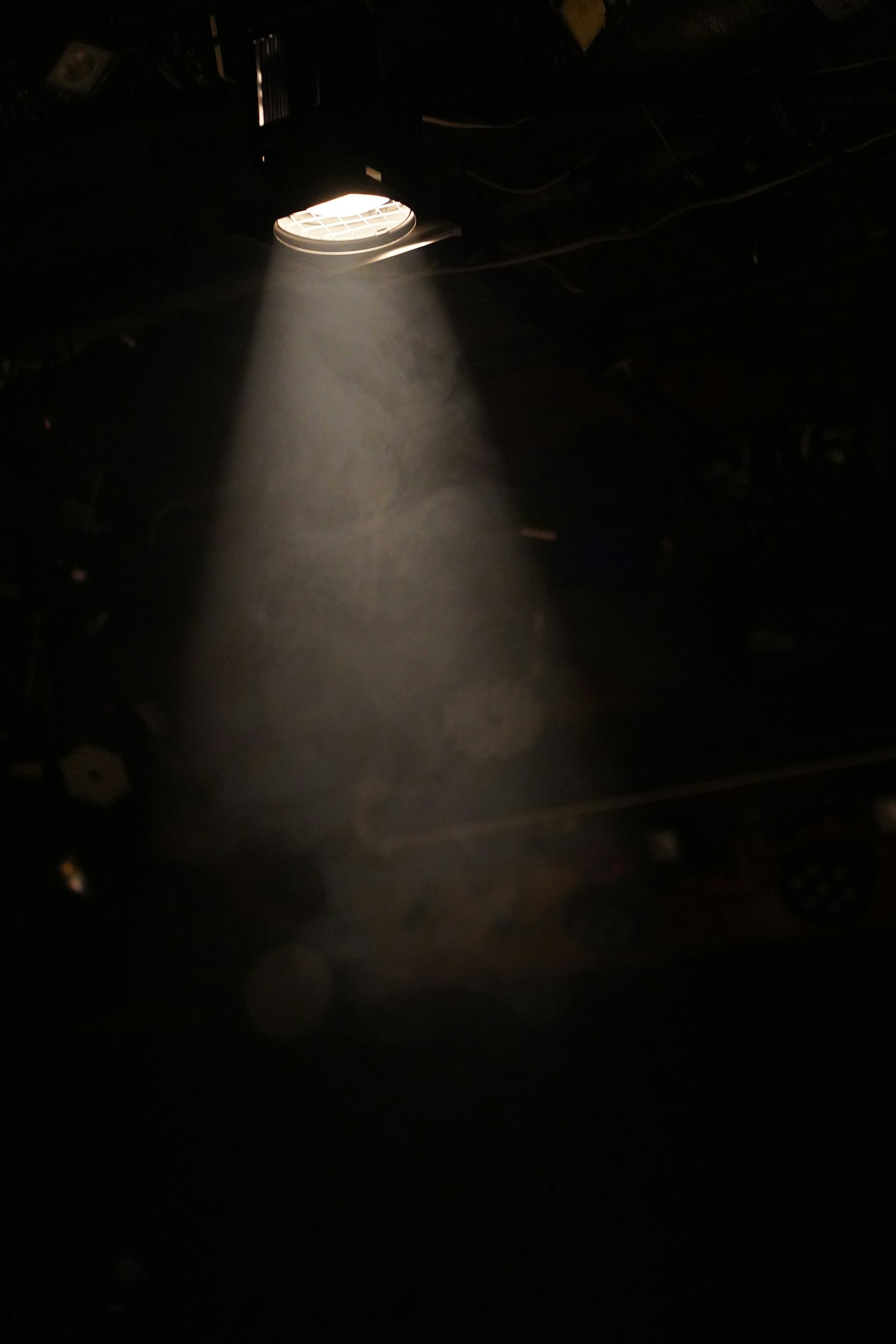 A single stage light casting a beam through haze onto an empty stage